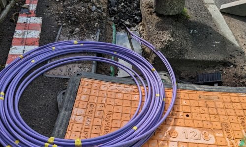 licensed-image (1) Fibre optic cable coming out of a trench curled up waiting to be installed for the UK gigabit broadband rollout being installed by the internet service providers ISPs across the country.
